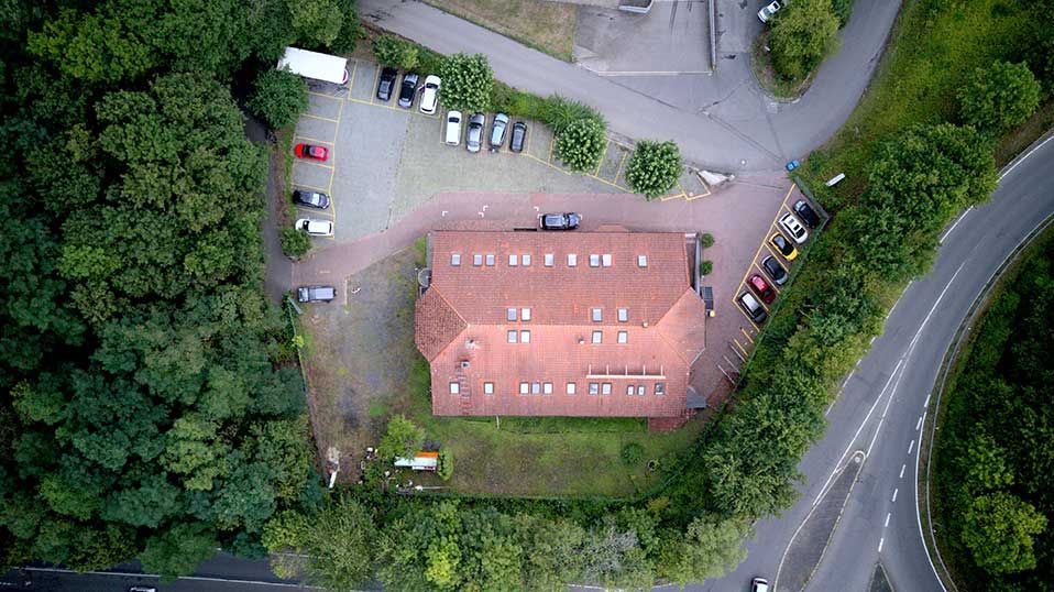 Luftaufnahme des Studios mit dem großen Parkplatz direkt am Gebäude